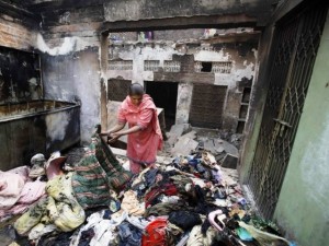 Shumaila, 48, looks through her family belongings at a section of her home, after it was burnt by a mob two days earlier, in Badami Bagh. PHOTO: REUTERS 