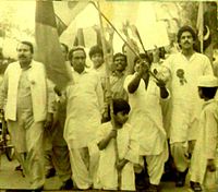 Fraz_Wahlah_as_a_Child_in_the_mid_80s_waving_Pakistan_Peoples'_Party_flag_whilst_leading_a_procession_against_the_Marshal_Law_and_dictatorship_of_General_Zia_ul_Haq_in_Pakistan,