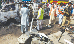 Source: DAWN: PESHAWAR: Security personnel and volunteers inspect the wreckage of the coach destroyed by the blast.—AFP