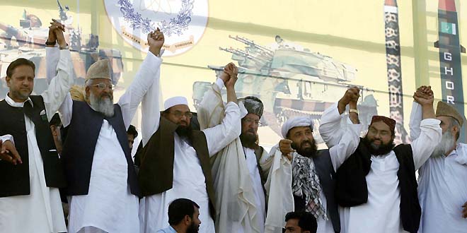 PESHAWAR, PAKISTAN, APR 15: Difa-e-Pakistan Council leaders, Mulana Sami-ul-Haq, Hafiz Mohmmad and other joint hands on stage during Difa-e-Pakistan conference held in Peshawar on Sunday, April 15, 2012. (Fahad Pervez/PPI Images).