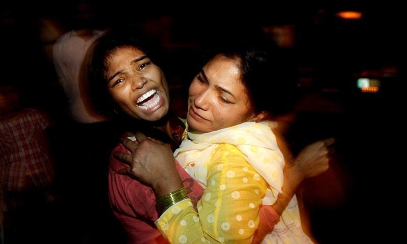 Family members consoling each other after their relative was killed in today's blasts. Image courtesy of DAWN /AP